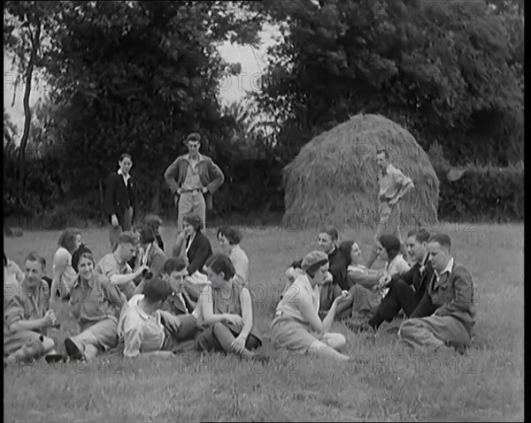 A Large Group of Hikers Having Drinks in a Field Beside a Haystack, 1931. Creator: British Pathe Ltd.