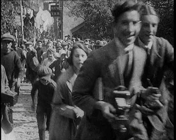 A Crowd Running up a Hilly Cobbled Street, 1920. Creator: British Pathe Ltd.