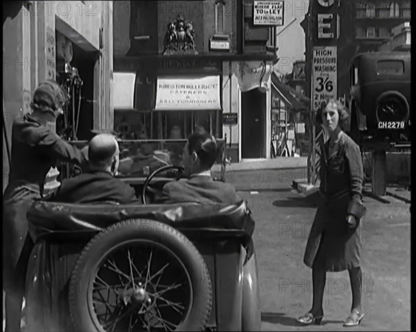 Female Civilians Working Petrol Pumps in a Garage and Filling up a Car, 1931. Creator: British Pathe Ltd.