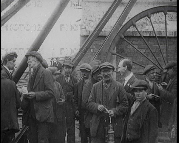 A Group of Miners Gathering and Smoking at a Pit Head, 1920. Creator: British Pathe Ltd.