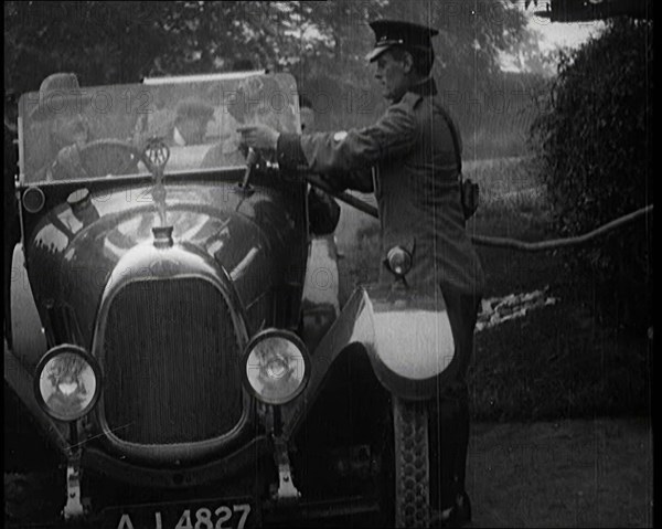 A British Automobile Association Employee Filling a Car With Petrol at a Petrol Station, 1920. Creator: British Pathe Ltd.