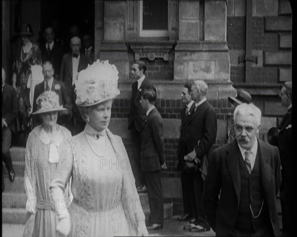 Queen Mary and King George V Accompanied by a Group of Officials Emerging from a Building , 1924. Creator: British Pathe Ltd.