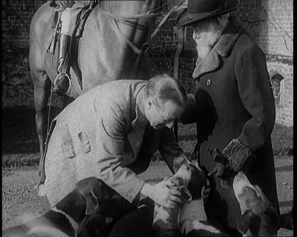 Prime Minister Stanley Baldwin Petting Dogs. Beside Him a Male Civilian Stands Next to a Horse, 1924 Creator: British Pathe Ltd.