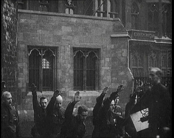 British Fascists Kneeling and Saluting in London. Some Are Carrying Flags, 1922. Creator: British Pathe Ltd.