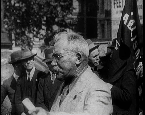 Male Civilian With Small Round Glasses and a Moustache Speaking.  Behind Are Male Civilians..., 1924 Creator: British Pathe Ltd.