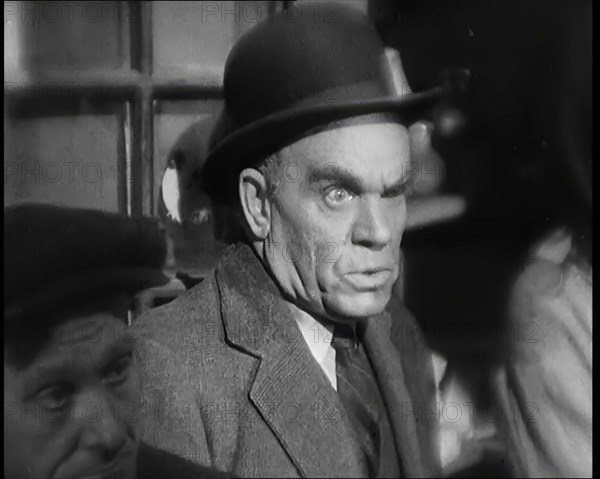 Scene from the Film 'The Informer':  Male Actor Looking at Money Being Thrown on the..., 1920s. Creator: British Pathe Ltd.