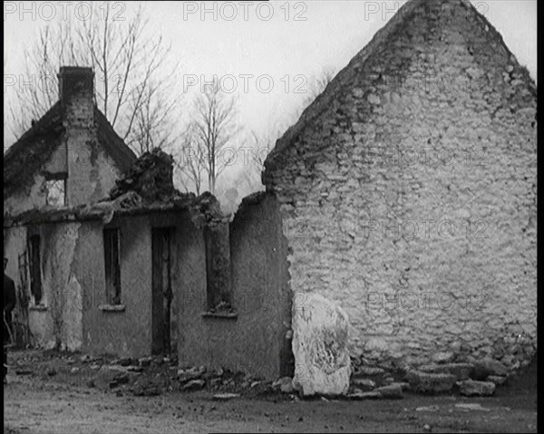 A Man Standing Outside a Burnt Out Cottage in Ireland, Holding a Bicycle, 1921. Creator: British Pathe Ltd.