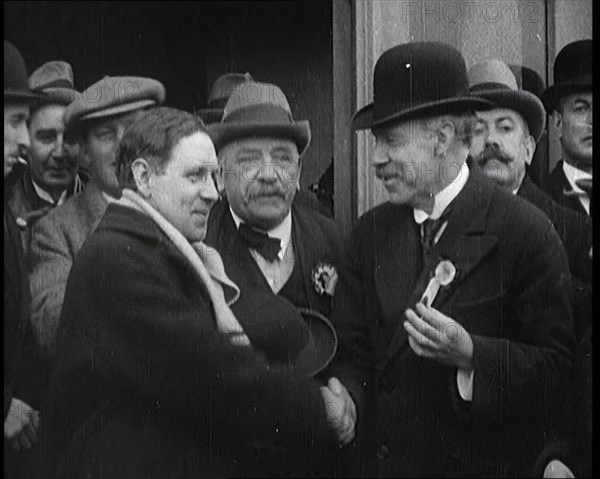 British Man Exiting a Building and Shaking Hands as Part of a by Election Campaign, 1921. Creator: British Pathe Ltd.