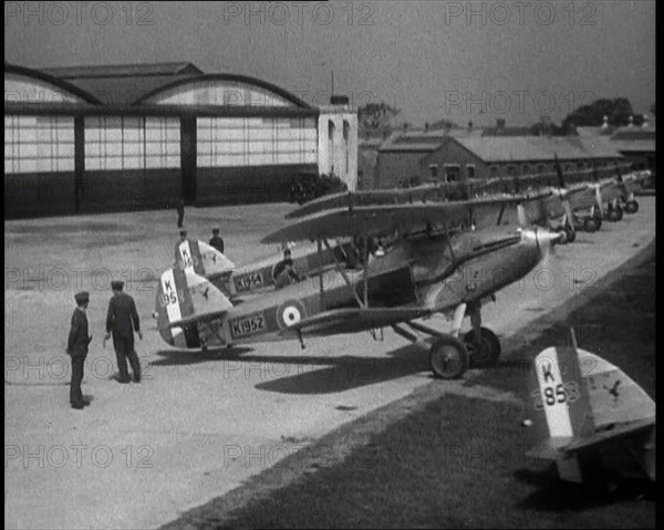 RAF Biplanes Taxiing Across a Field at tended to by Their Aircrews, 1933. Creator: British Pathe Ltd.