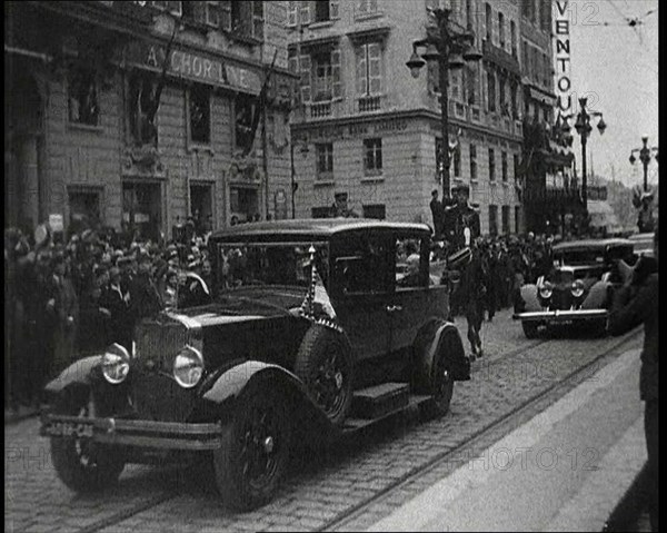 Cars Driving Down a Road, Watched by a Crowd, 1934. Creator: British Pathe Ltd.