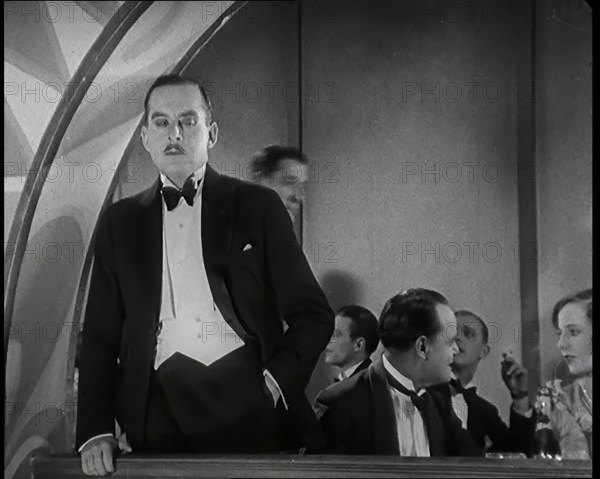 Scene from the Film 'Champagne': Male Actor Standing on a Balcony Overlooking the Nightclub...,1920s Creator: British Pathe Ltd.