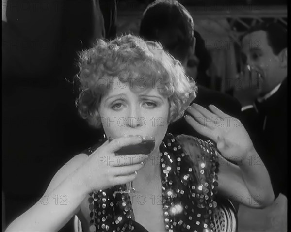 Scene from the Film 'Champagne': Betty Balfour in a Nightclub Drinking Champagne, 1920s. Creator: British Pathe Ltd.