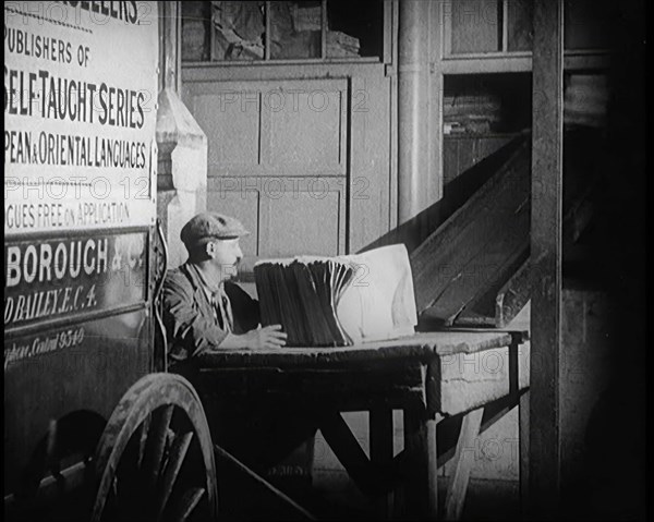 A Man Loading Bundles of Newspapers Into a Van, 1921. Creator: British Pathe Ltd.