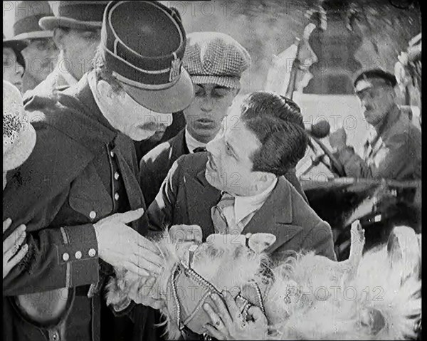 Scene from the Film 'The Compulsory Husband': Monty Banks Holding a Dog That He Has Run Over, 1920s. Creator: British Pathe Ltd.