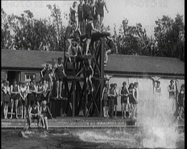 British People Jumping from Various Tiers of Diving Boards at the Chiswick Open Air Baths, 1920. Creator: British Pathe Ltd.