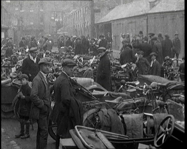 Men Standing Around Groups of Motorcars and Motorbikes, 1920. Creator: British Pathe Ltd.