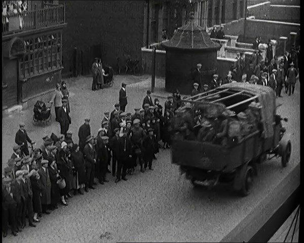 Supply Trucks With Armed Guards Driving Alongside a Crowd of Civilians, 1926. Creator: British Pathe Ltd.