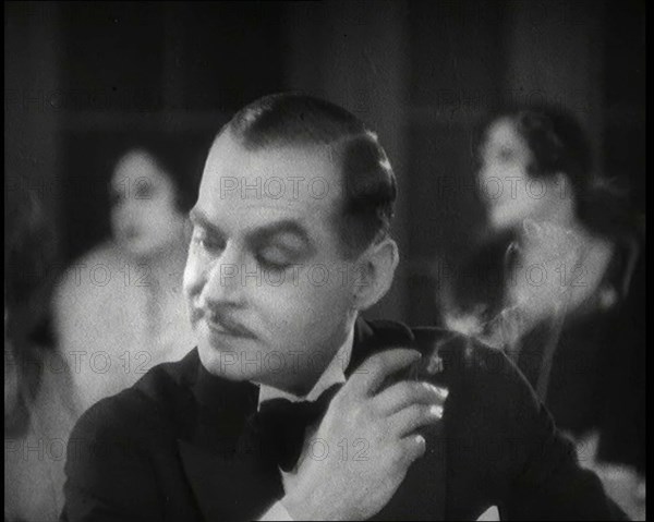 Scene from the Film 'Champagne': a Male Actor in a Nightclub Smoking a Cigarette, 1920s. Creator: British Pathe Ltd.