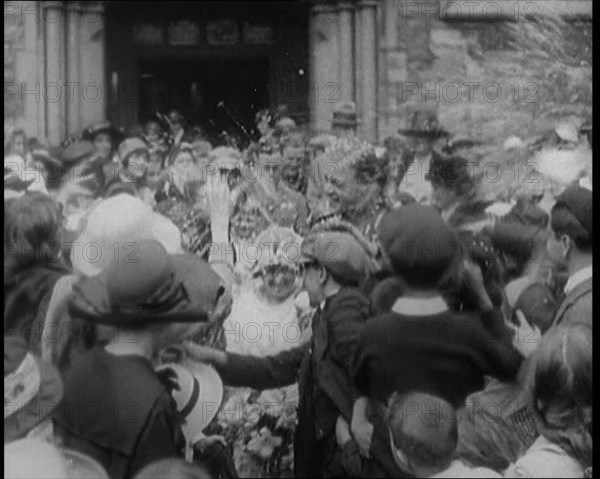 British Bride and Groom Exiting a Church After Their Wedding Ceremony. Guests Are Throwing..., 1921. Creator: British Pathe Ltd.