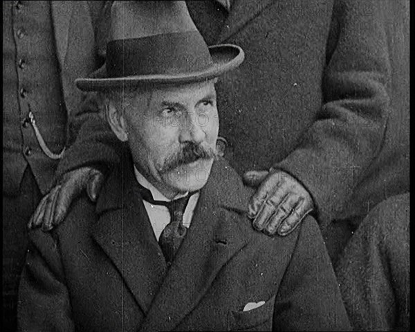 British Prime Minister Ramsay MacDonald Sitting Down. a Pair of Hands Rests on His Shoulders, 1924. Creator: British Pathe Ltd.