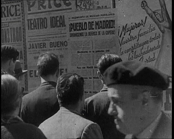 Residents of Madrid Looking at Government Posters on a Wall, 1937. Creator: British Pathe Ltd.