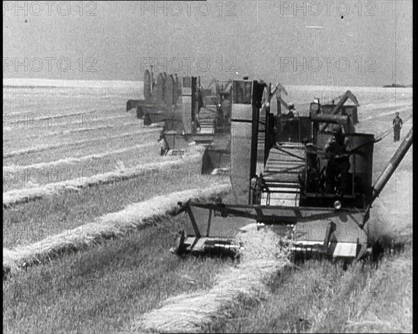 A Line of Tractors Harvesting Grain, 1932. Creator: British Pathe Ltd.