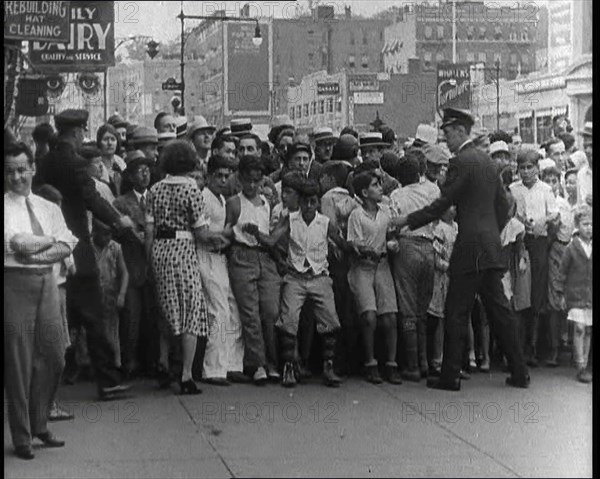 Crowded New York City Street Where Police and Ambulance Attend to Dead and Dying Victims..., 1932. Creator: British Pathe Ltd.