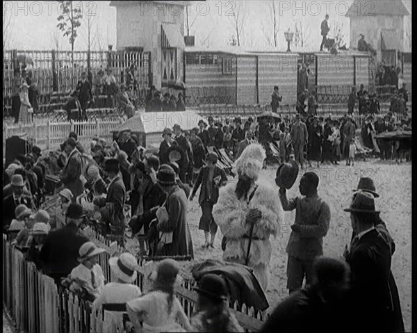 A Crowd of People Watch as Others Ride a Model Train Which Passes Them, 1924. Creator: British Pathe Ltd.