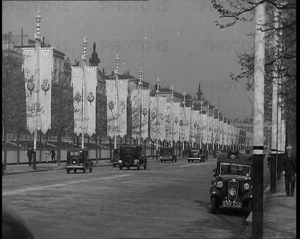 Cars Driving Down the Mall Which Is Decorated By Flags For the Coronation of King George VI, 1937. Creator: British Pathe Ltd.