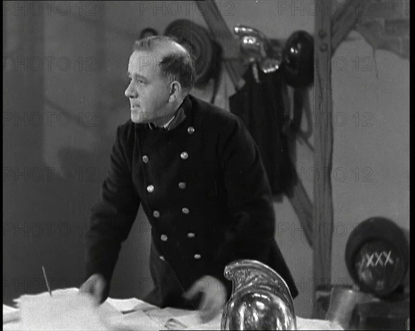 A Close up of Comedian Robb Wilton on Set Playing a Fire Brigade Officer and Standing at a..., 1938. Creator: British Pathe Ltd.