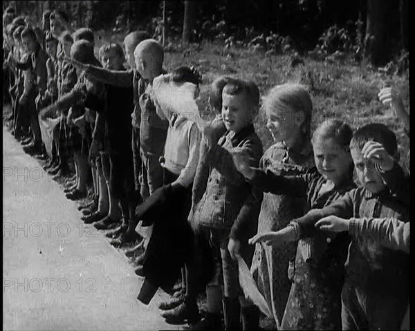 German Children Standing By the Side of a New Road, Some of Them Raising Their Arms in a..., 1937. Creator: British Pathe Ltd.