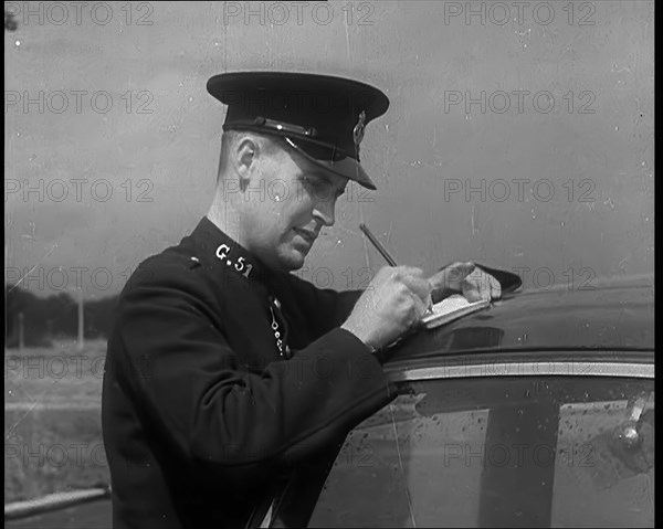 A Police Officer Writing a Ticket for a Car, 1940. Creator: British Pathe Ltd.