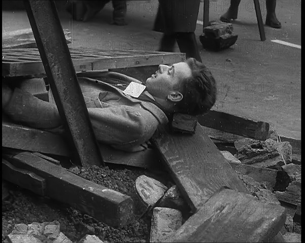 British People Acting Out Bomb attacks and Crashed German Planes, Lying Under Rubble, 1940. Creator: British Pathe Ltd.