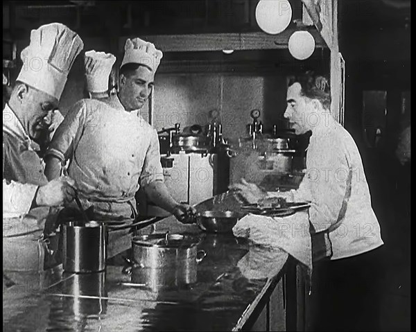 A Galley With Kitchen Staff Cooking and Waiters With Dishes on Board the 'Strength Through..., 1939. Creator: British Pathe Ltd.