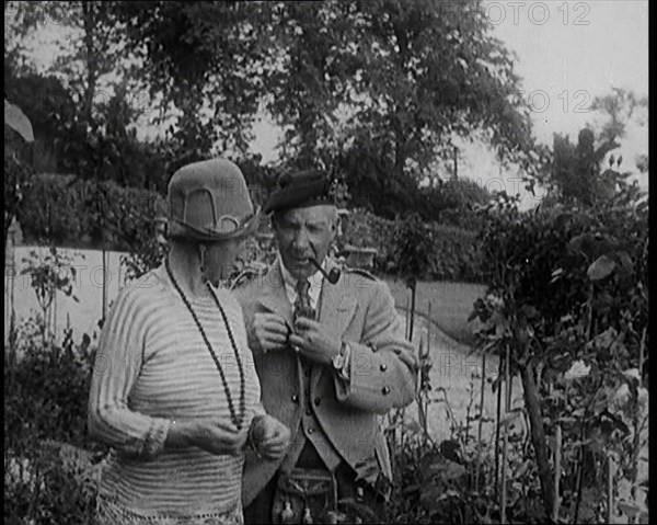 Sir Harry Lauder Giving Flowers to His Wife, Lady Ann Lauder, at Home in Scotland, 1920s. Creator: British Pathe Ltd.