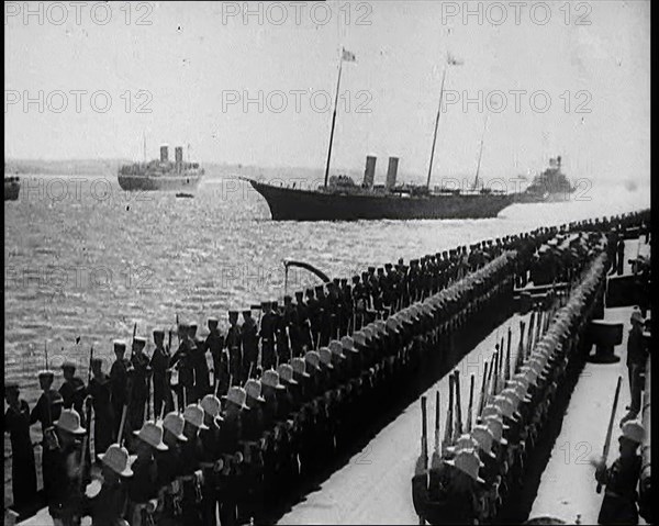 British Sailors Standing to Attention as British Warships Sail Past, 1935. Creator: British Pathe Ltd.