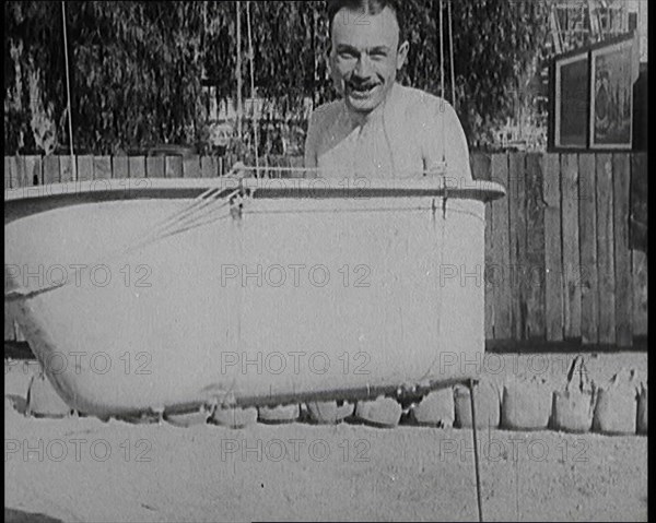 A Male Civilian Sitting in a Bath Before the Bath is Lifted Off the Ground By a Hot Air..., 1920s. Creator: British Pathe Ltd.