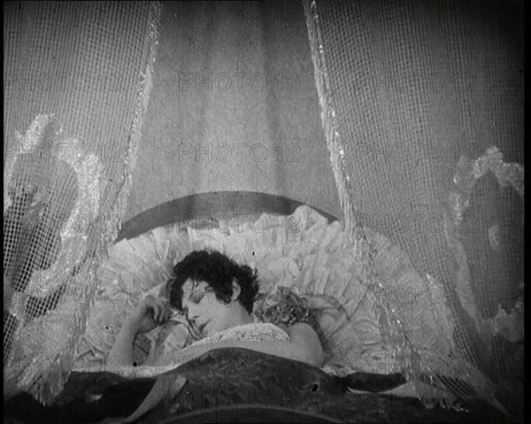 Scene from a 1920s Film. A Female Actor Sleeping in a Bed, 1920s. Creator: British Pathe Ltd.