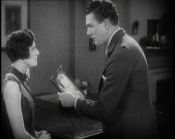 Carl Brisson and Lilian Hall-Davis Acting in a Scene. Carl Brisson is Holding a Framed..., 1920s. Creator: British Pathe Ltd.