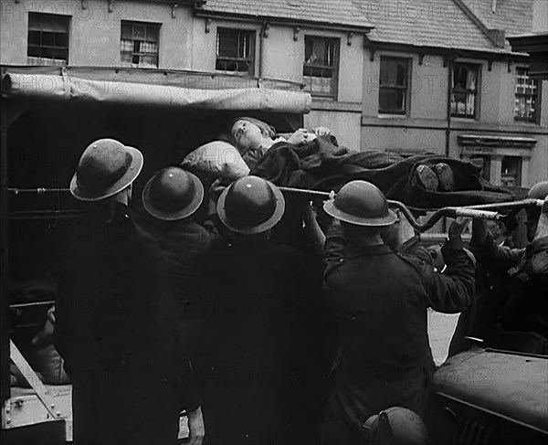 An Injured Child Being Carried Into an Ambulance, 1940. Creator: British Pathe Ltd.