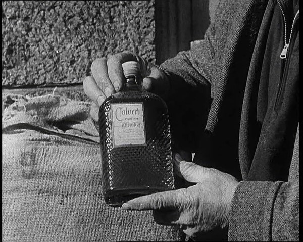 A Man Holding a Bottle of Liquor, 1932. Creator: British Pathe Ltd.