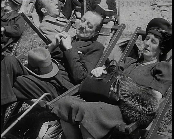 A British Couple Asleep in Deckchairs in the Sunshine in Hyde Park, the Man Has His Legs.., 1938. Creator: British Pathe Ltd.