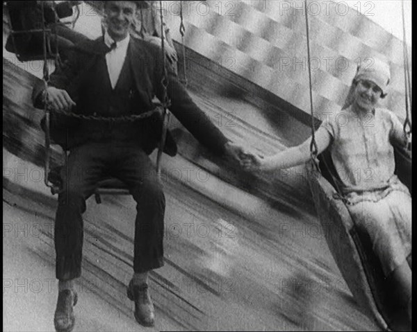 A Male Civilian and a Female Civilian Holding Hands as They Are Spun Through the Air on a..., 1924. Creator: British Pathe Ltd.