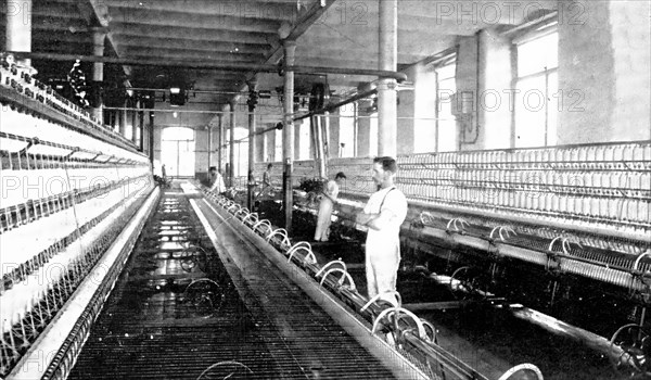 Spinning the cotton into yarn: a great spinning-mule in use, 1909. Creator: Unknown.