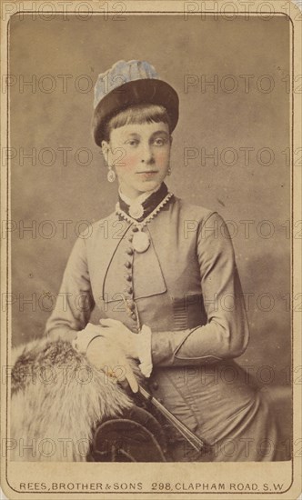 Unidentified woman standing, holding a fan, 1879. Creator: David Rees & Brother & Son.