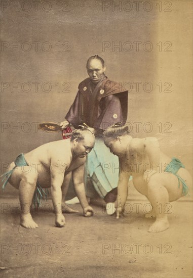 Two Japanese sumo wrestlers posed with referee, 1868-1880. Creator: Felice Beato.