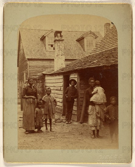 Portrait of a Black family standing in front of a house, 1886. Creator: George Barker.