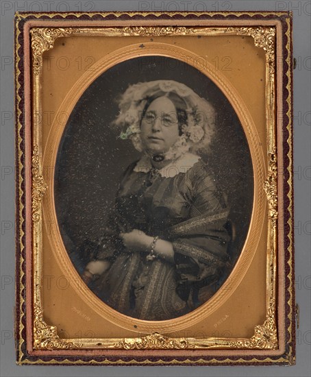 Portrait of a middle-aged woman wearing wire-rimmed glasses in flower embellished veil, 1855-1860. Creator: James McClees.