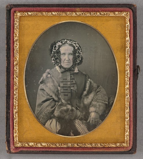 Portrait of an elderly woman wearing a hat, fur coat and gloves, seated, about 1855. Creator: Unknown.