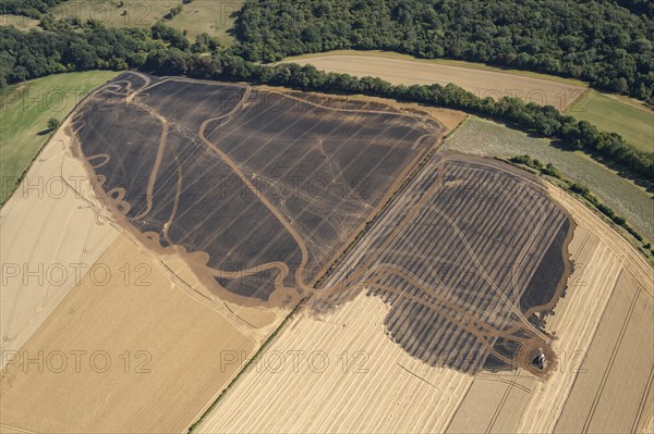 A burnt out combine harvester and fire scorched fields near Pleasley, Derbyshire, 2022. Creator: Emma Trevarthen.